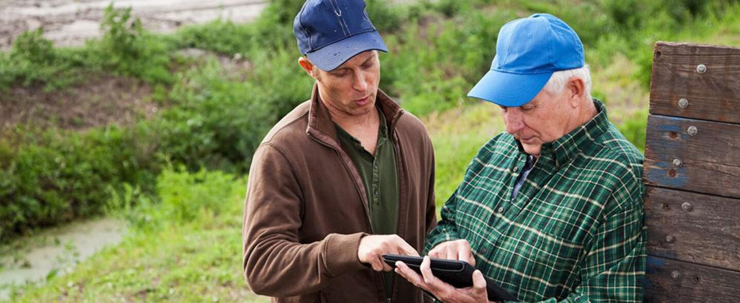 Two farmers looking at ipad