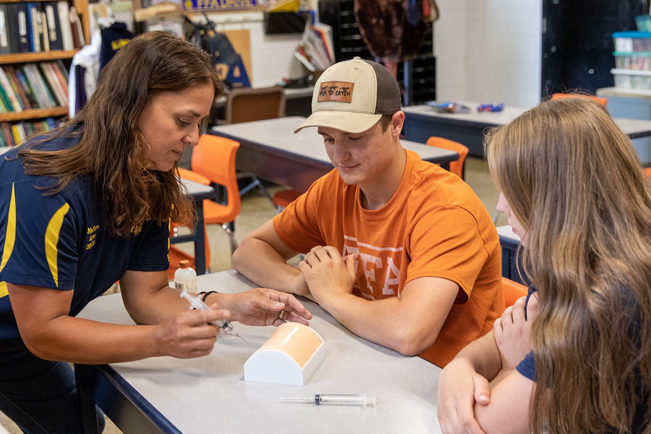 An FFA Advisor and Ag Teacher helps students in the classroom
