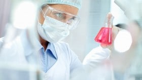 Researcher_inspecting_solution_2-min